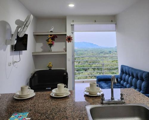 a kitchen with a sink and a kitchen with a view at Apartamento Vacacional Girardot Aqualina Green in Girardot