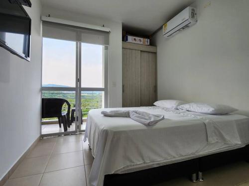 1 dormitorio con cama y ventana grande en Apartamento Vacacional Girardot Aqualina Green en Girardot