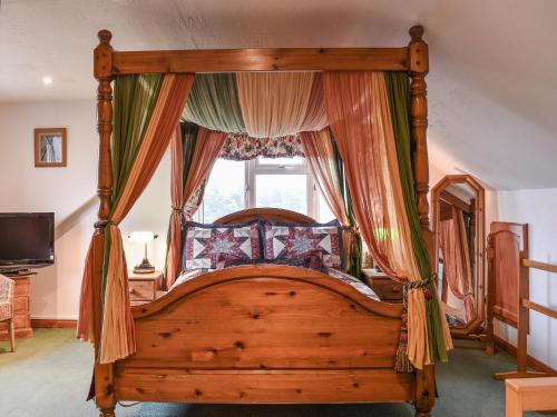 a bedroom with a canopy bed with a window at Shiralee in Middle Winterslow