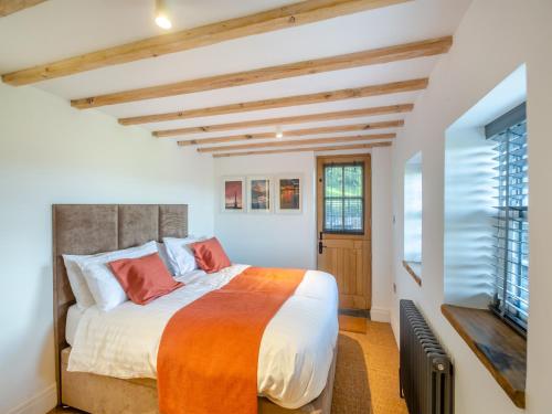 a bedroom with a large bed and a window at Yr Allt in Abergele