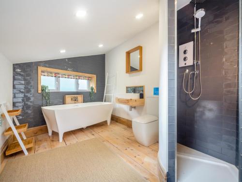 a bathroom with a tub and a toilet and a sink at Yr Allt in Abergele