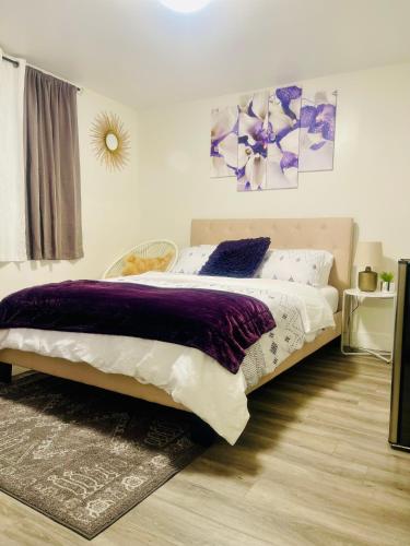 a bedroom with a large bed with purple and white sheets at Premium Suite in London