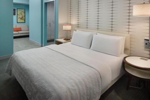 a bedroom with a large white bed and a table at Le Meridien Tampa, The Courthouse in Tampa