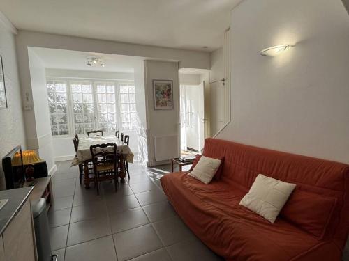 un salon avec un canapé rouge et une table dans l'établissement Appartement 6/8 pers, centre-ville avec jardin, proche télécabines - FR-1-234-311, à Cauterets