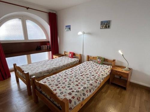 une chambre avec deux lits et une fenêtre dans l'établissement Appartement 6/8 pers, centre-ville avec jardin, proche télécabines - FR-1-234-311, à Cauterets