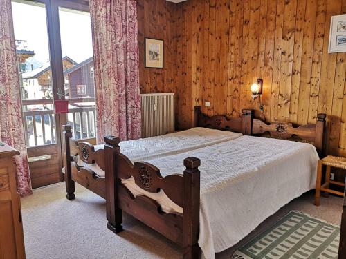 a bedroom with a bed in a room with wooden walls at Appartement Notre-Dame-de-Bellecombe, 2 pièces, 4 personnes - FR-1-595-90 in Notre-Dame-de-Bellecombe