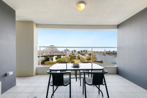 a dining room with a table and chairs and a large window at River Place hosted by AAB in Brisbane