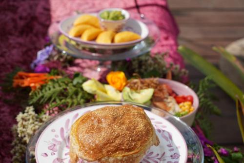 a plate of food with a sandwich and a salad at Bethel Lozana Guatape in Guatapé