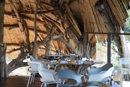 a dining room with a table and white chairs at Bethel Lozana Guatape in Guatapé