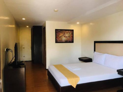 a bedroom with a bed and a television in it at Subic Grand Seas Resort in Olongapo