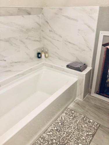 a white bath tub in a bathroom with marble walls at The Whitmore Inn in Weaverville