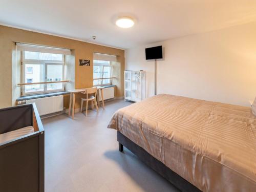 Dormitorio con cama, escritorio y TV en Luxury Family Holiday Home With Wellness, en Binsfeld