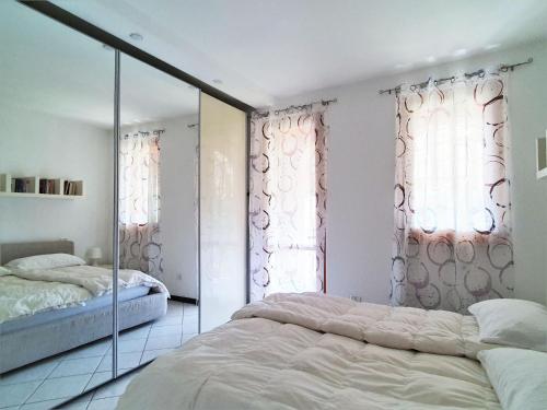 a bedroom with a bed and two windows at Belvilla by OYO BOS03 3 in Grantola
