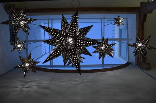 un grupo de estrellas colgando en una habitación en El Suburbio - Serapio Rendon en Morelia