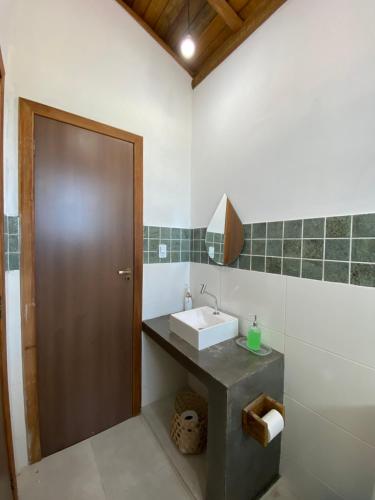 baño con lavabo y puerta marrón en Taipu de Fora - Villa Ohana Flats en Taipu