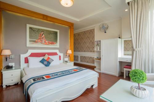 una camera da letto con un grande letto bianco e un tavolo di Anh Dao Hotel ad Ho Chi Minh