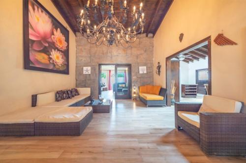 a living room with couches and a chandelier at Casa Luna in Palm-Eagle Beach