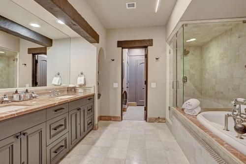 a bathroom with two sinks and a tub and a shower at The Arrabelle at Vail Square, a RockResort in Vail