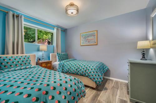 a blue bedroom with two beds and a window at Cloudside Hotel in Nelson