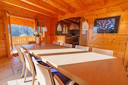 une salle à manger avec une longue table et des chaises dans l'établissement Chalet Nicole, à La Côte dʼArbroz