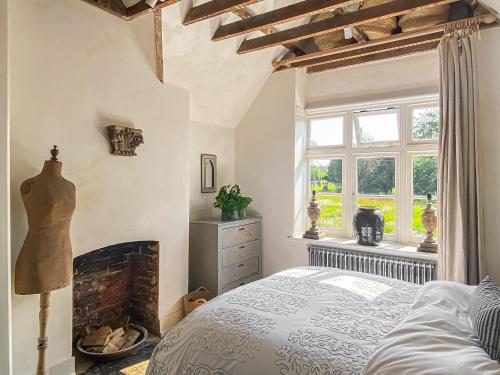 a bedroom with a bed and a fireplace at Campbell Cottage in Ticehurst