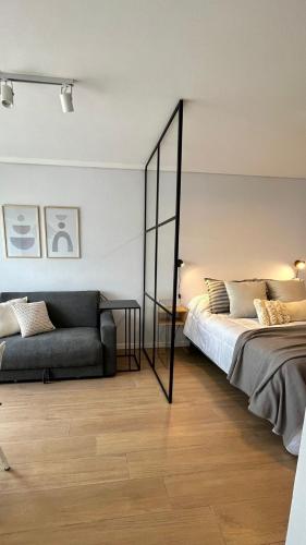 un dormitorio con una cama y un sofá en Nuevo estudio al mar con cochera, en Mar del Plata