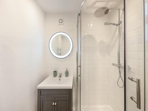 a bathroom with a sink and a shower with a mirror at Rose Cottage in Llanfair-Dyffryn-Clwyd