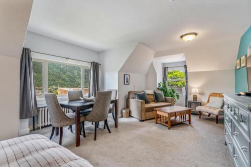 a living room with a table and chairs and a couch at Cloudside Hotel in Nelson
