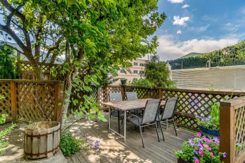 a wooden deck with a table and chairs on it at Cloudside Hotel in Nelson