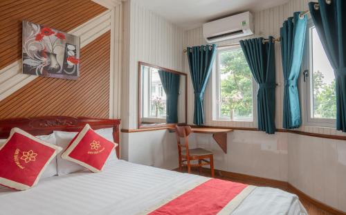 een slaapkamer met een bed met blauwe en rode kussens bij Hotel Nhu Y 2 in Ho Chi Minh-stad