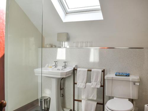 a white bathroom with a sink and a toilet at Gleneffock Farmhouse in Tarfside