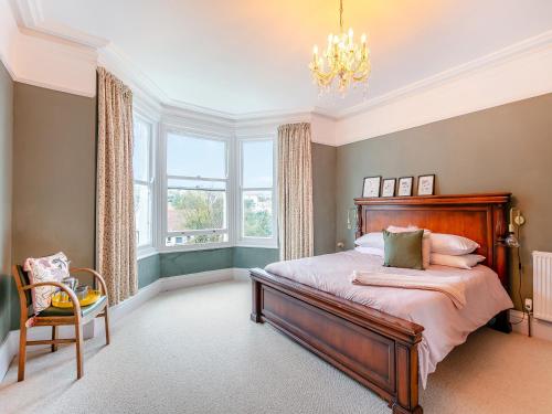 a bedroom with a bed and a chandelier at Hillside in Paignton