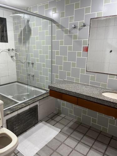 uma casa de banho com uma banheira, um WC e um lavatório. em Apartamento com vista da praia da Costa 615 em Vila Velha