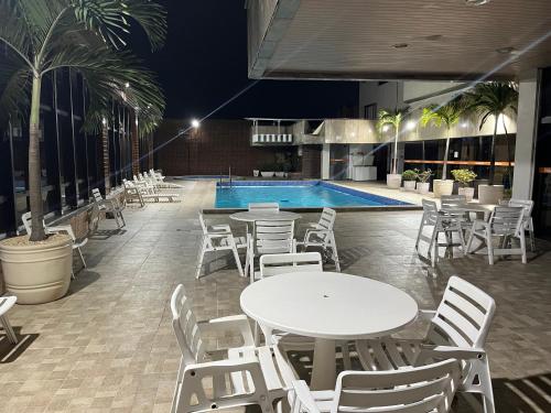 a pool with tables and chairs next to a pool at Apartamento com vista da praia da Costa 615 in Vila Velha