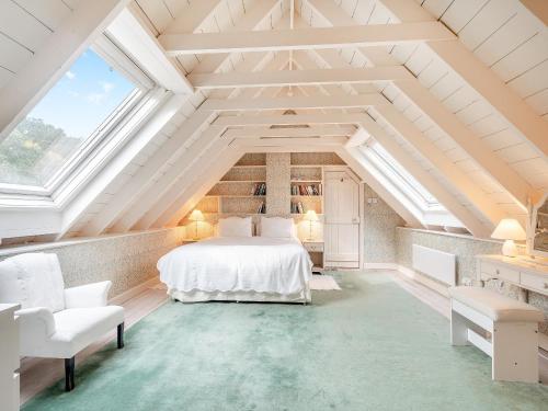 a bedroom with a white bed in a attic at Inverglen Farm in Strachur