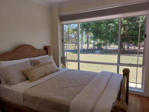 um quarto com uma cama e uma grande janela em Countryside Retreat - Visit our private apartment on our acreage property! em Park Ridge