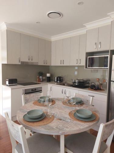 a kitchen with a table with plates and glasses on it at Luxurious Countryside Retreat - Visit our private apartment on our acreage property! in Park Ridge