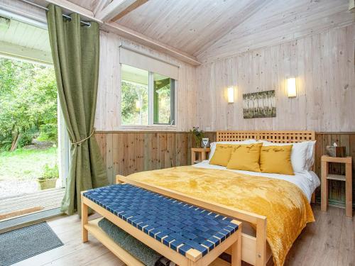 ein Schlafzimmer mit einem Bett und einem großen Fenster in der Unterkunft Laughing Waters in Chillaton