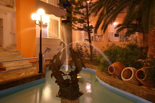 a fountain in the middle of a building at Dolphin Hotel in Skopelos Town