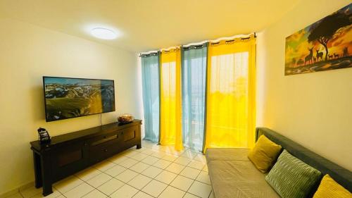 een woonkamer met gele gordijnen en een bank bij Lev Eilat 2 bedrooms in Eilat