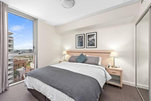 a bedroom with a bed and a large window at Heart of the CBD ~ 1Bed/1Bath/Balcony/Free Parking in Brisbane