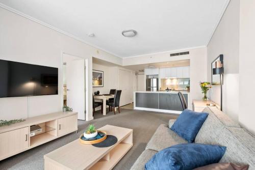 a living room with a couch and a tv at Heart of the CBD ~ 1Bed/1Bath/Balcony/Free Parking in Brisbane