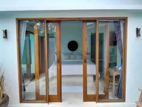 a bedroom with sliding glass doors with a bed at Villa Giyor in Nusa Lembongan
