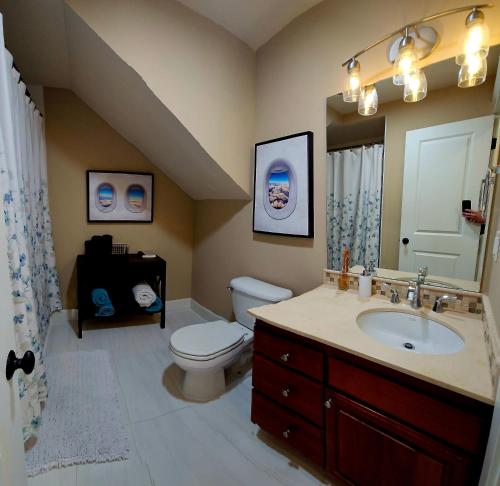 a bathroom with a toilet and a sink and a mirror at 4 Story Lakeside Home In Heart of Lake Union - Queen Anne Neighborhood in Seattle
