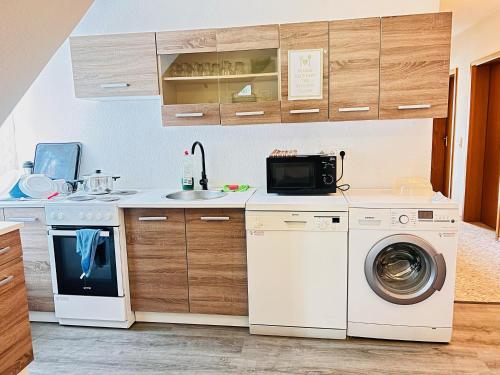 een keuken met een wasmachine en een wastafel bij Monteur-Zimmervermietung Visselhövede in Visselhövede