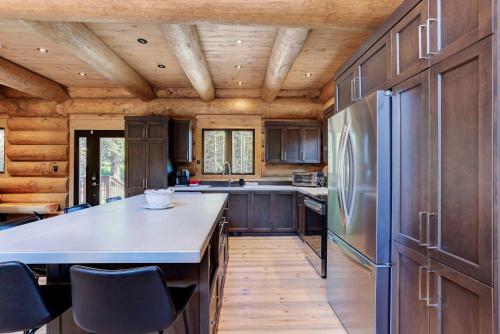 a kitchen with wooden cabinets and a refrigerator at Tremblant chalet O-Spa in Lac-Superieur