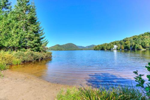 a view of a lake with trees on the shore at Tremblant chalet O-Spa in Lac-Superieur