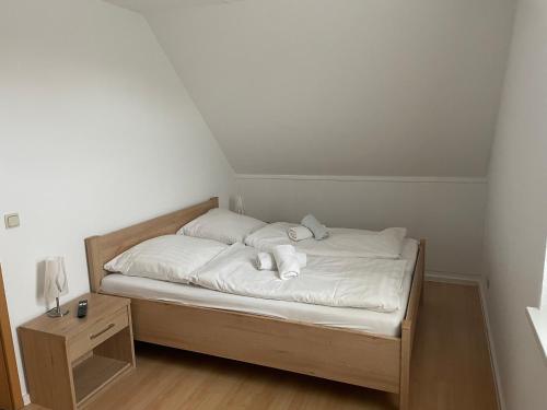 um pequeno quarto com uma cama com lençóis brancos em Ferienwohnungen Ryck Blick em Greifswald