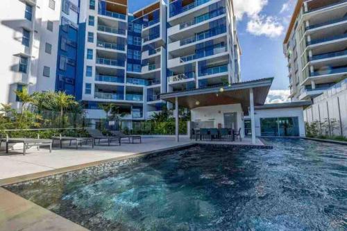 einem Pool vor einem Gebäude in der Unterkunft Oceanus Luxe Beachfront Bokarina in Kawana Waters