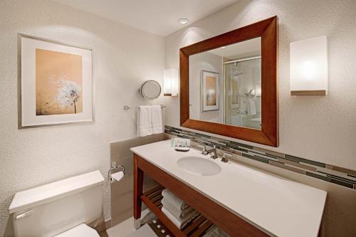 La salle de bains est pourvue d'un lavabo, d'un miroir et de toilettes. dans l'établissement The Westin Calgary, à Calgary